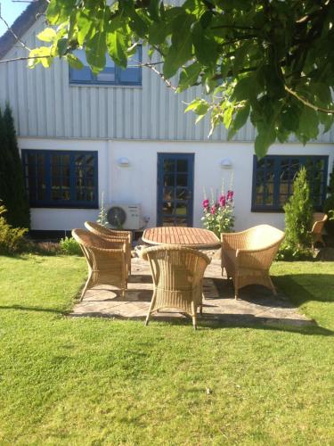 a picnic table and four chairs in a yard at Rane Ladegaard in Ebeltoft