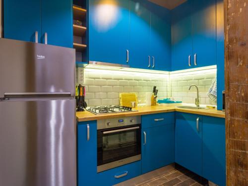 a kitchen with blue cabinets and a stainless steel refrigerator at Maniu Home in Cluj-Napoca