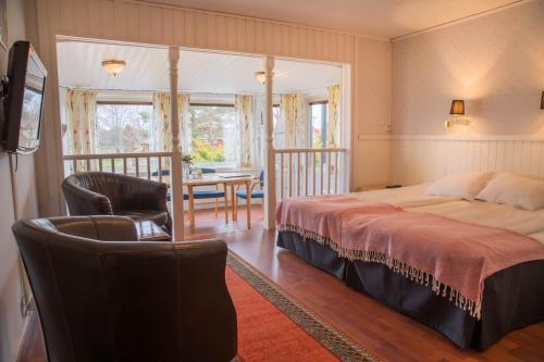 ein Schlafzimmer mit einem Bett, einem Stuhl und einem Tisch in der Unterkunft Wärs - Wärdshuset på Dal in Mellerud