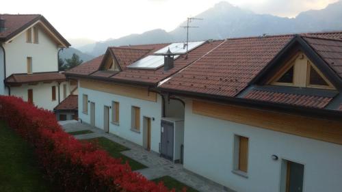 Cassina ValsassinaにあるCasa Stella Alpinaの赤い屋根と花並木