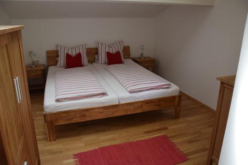 a bedroom with a bed with red pillows on it at Schmalzgrubengut in Bad Hofgastein