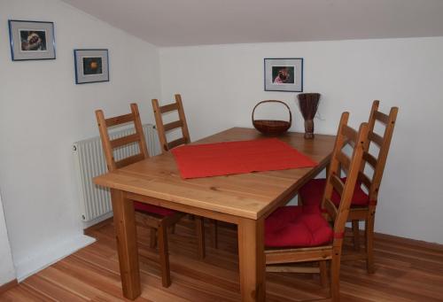 a wooden table with chairs and a red napkin on it at Schmalzgrubengut in Bad Hofgastein