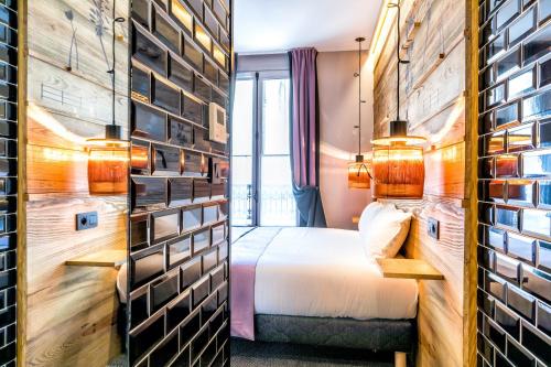a hotel room with a bed and a wall with pictures at Hotel Restaurant Au Boeuf Couronné in Paris
