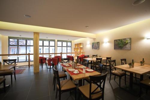 ein Esszimmer mit Tischen und Stühlen in einem Restaurant in der Unterkunft Weingut & Gästehaus Schmitz-Bergweiler in Bernkastel-Kues