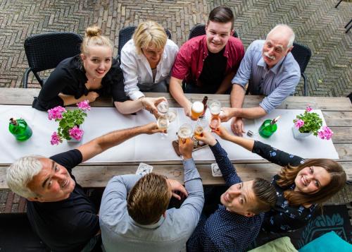 a group of people sitting around a table drinking beer at Hotel Restaurant Taverne in Twello