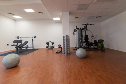 a gym with several exercise equipment in a room at Dwie Sosny - Apartament 48 in Ustronie Morskie