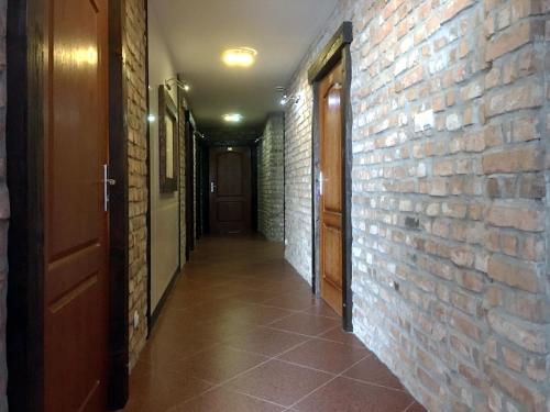 an empty hallway with a brick wall and a door at Hotel Kameleon in Tarnobrzeg