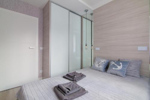 a bedroom with a bed with two towels on it at Dwie Sosny - Apartament 48 in Ustronie Morskie
