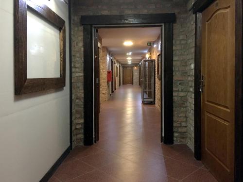 a long hallway with a brick wall and a hallway with a door at Hotel Kameleon in Tarnobrzeg
