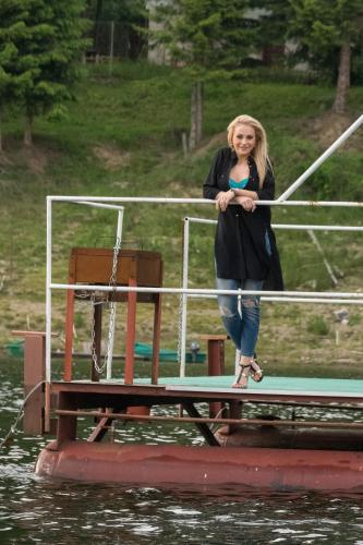 a woman standing on a pier on a boat at Pensiunea Vis Alpin Belis in Beliş