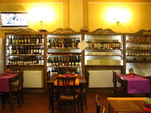 a restaurant with tables and bottles of wine at Locanda Dei Baroni - Antica Dimora in Camaldoli