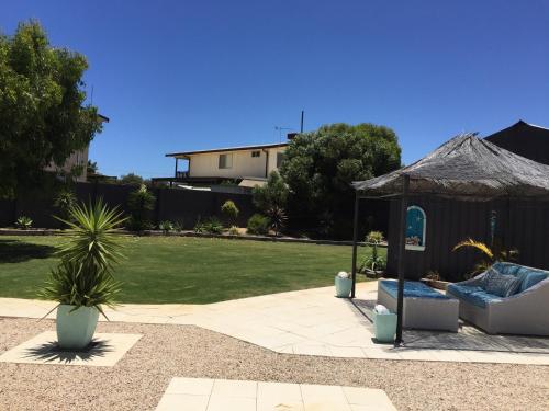 a patio with a gazebo and a couch and a grass yard at Aqua Shack Jurien Bay in Jurien Bay