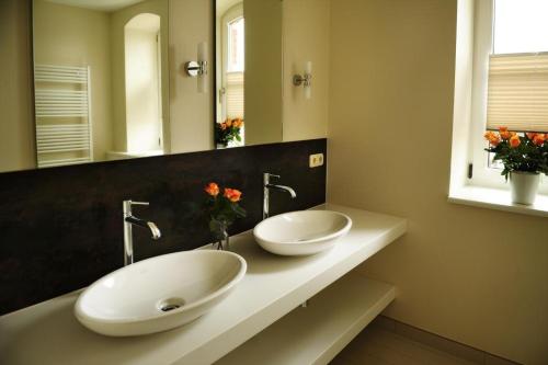 a bathroom with two white sinks on a counter at Zum Kaiserlichen Postamt in Parchim