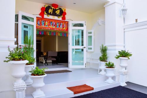 an entrance to a house with potted plants at Shunli Hotel - SHA Extra Plus in Phuket Town