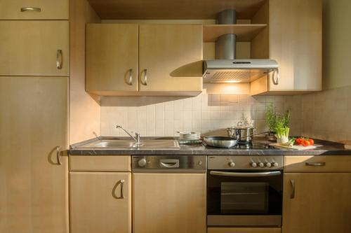 a kitchen with a sink and a stove top oven at Romantik Hotel Jagdhaus Eiden am See in Bad Zwischenahn