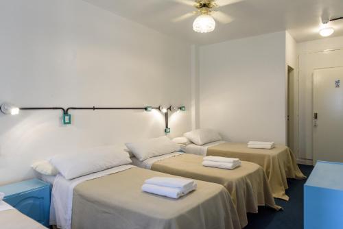 a room with three beds with towels on them at Casa Urbana Hotel in Cordoba