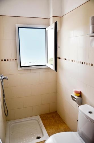 a bathroom with a window and a toilet at Hostal Alocs in Es Figueral Beach