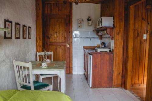 cocina con mesa y cocina pequeña con fogones en Hosteria Las Cartas en San Carlos de Bariloche