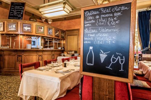 a dining room with a table with a chalkboard at Hotel Restaurant Au Boeuf Couronné in Paris