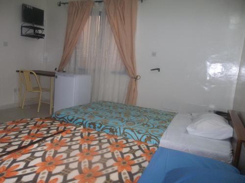 a small bedroom with a bed and a window at Residence Le Cailcedrat in Ouagadougou