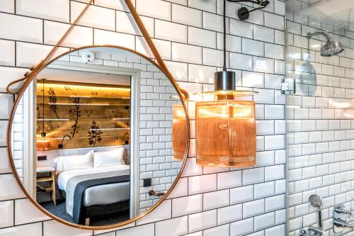 a bathroom with a mirror and a bed in a room at Hotel Restaurant Au Boeuf Couronné in Paris