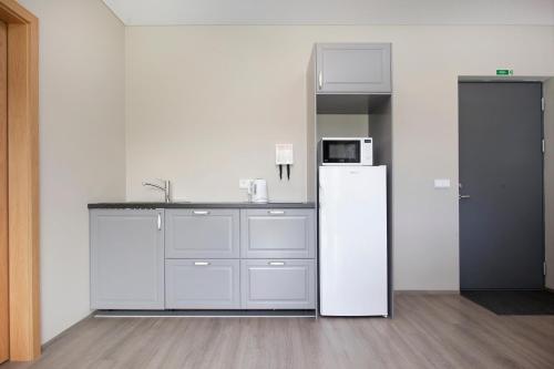 a kitchen with a refrigerator, stove, sink and microwave at Arnarstapi Hotel in Stapi