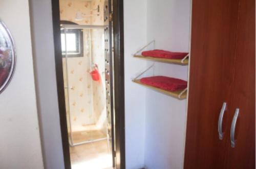 a room with a closet with a glass door and shelves at Ohana Beach in Saquarema