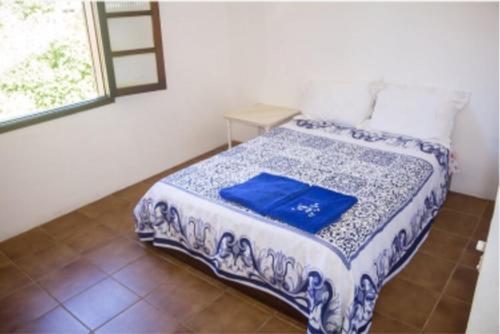 a blue and white bed in a room with a window at Ohana Beach in Saquarema
