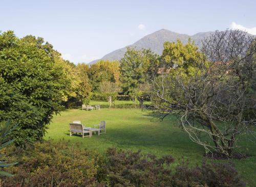 a park with benches and tables in the grass at Park Hotel Villa Belvedere in Cannobio