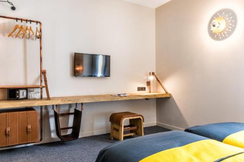 a room with a desk and a bed and a bed sidx sidx sidx at Hotel Restaurant Au Boeuf Couronn&eacute; in Paris