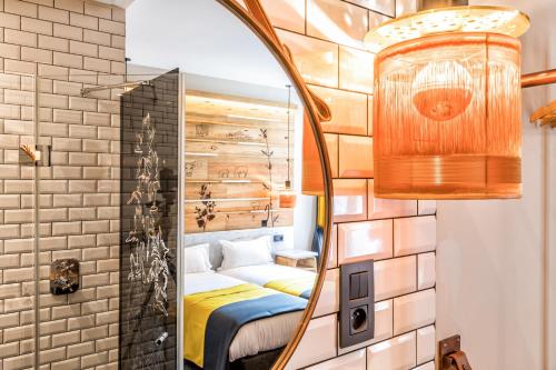 a bedroom with a mirror and a bed in a room at Hotel Restaurant Au Boeuf Couronné in Paris
