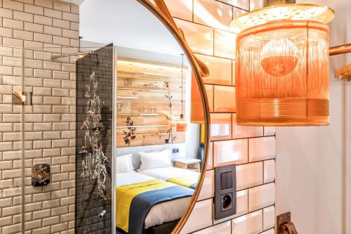 ein Schlafzimmer mit einem Spiegel und einem Bett in einem Zimmer in der Unterkunft Hotel Restaurant Au Boeuf Couronné in Paris