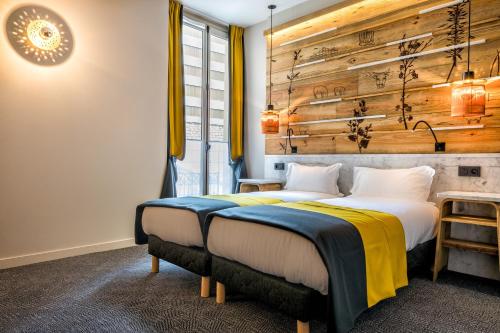 a bedroom with two beds and a wooden wall at Hotel Restaurant Au Boeuf Couronné in Paris