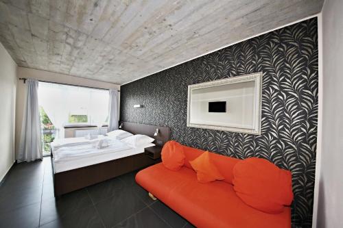 1 dormitorio con cama, sofá y lavamanos en Pension Jezerná en Zduchovice