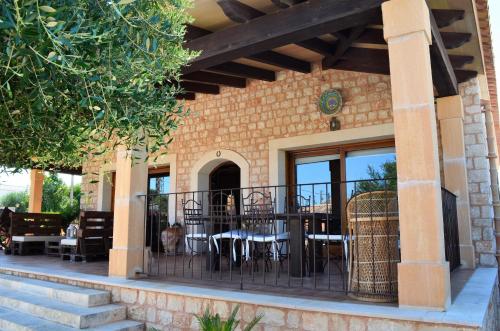 a house with a balcony with tables and chairs at Ca Na Marina in Cala Llombards