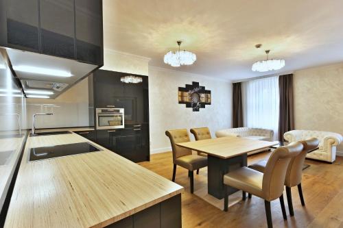 a kitchen and dining room with a table and chairs at Wellness Hotel Republika 24 Apartments in Plzeň