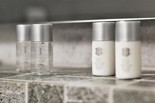 a group of three bottles sitting on a counter at Wellness Hotel Republika 24 Apartments in Plzeň