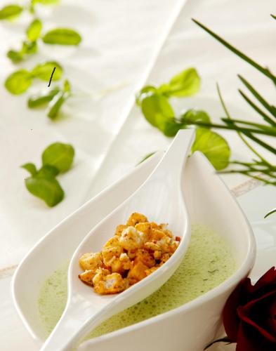 a white plate with a bowl of green sauce at Landhotel Schneider in Riedenburg