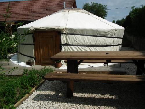 une yourte avec une table de pique-nique en bois et un banc dans l'établissement yourte d'hotes, à Mailley-et-Chazelot