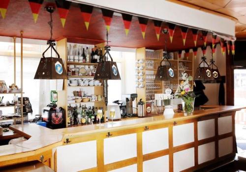 a bar with a wooden counter and some flags at Hotel Goldener Hahn in Duisburg