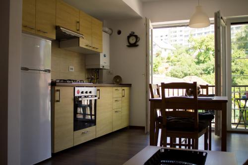 ブラショヴにあるAvram Iancu Private Apartmentのキッチン(白い冷蔵庫、テーブル、椅子付)