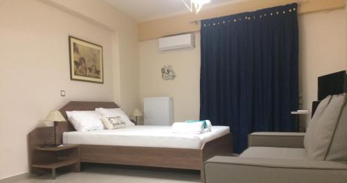 a bedroom with a bed and a chair and a blue curtain at Super 36sqm Junior Suite in luxurious picturesque area in Piraeus