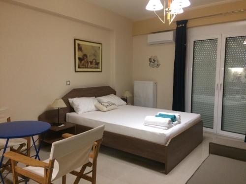 Schlafzimmer mit einem Bett, einem Tisch und Stühlen in der Unterkunft Super 36sqm Junior Suite in luxurious picturesque area in Piräus