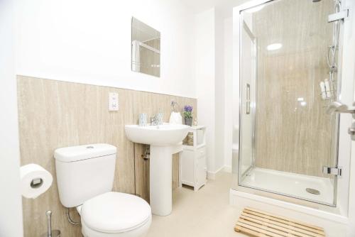 y baño con aseo, lavabo y ducha. en Modern Central Apartment en Aberdeen