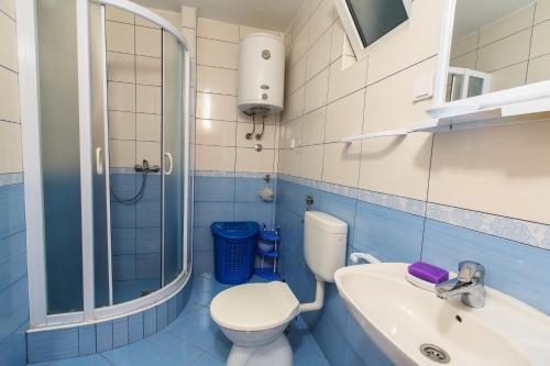 a blue and white bathroom with a toilet and a sink at De Lux Apartments Luka in Bar