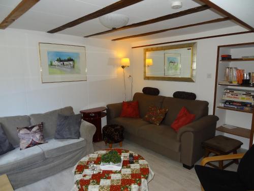 a living room with a couch and a table at La Fermette Blanche in Nadrin