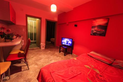 a red bedroom with a bed and a television at De Lux Apartments Luka in Bar