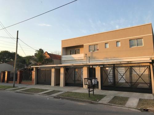 a building with two garage doors on a street at Mendoza Apartments Ezeiza Airport in Luis Guillón
