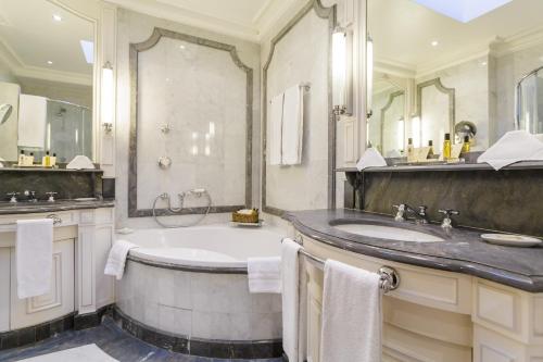 a bathroom with a tub and a sink at Hotel Luxembourg Parc in Paris