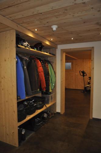 a room with a closet filled with clothes and shoes at Chesa Viletta in La Punt-Chamues-ch